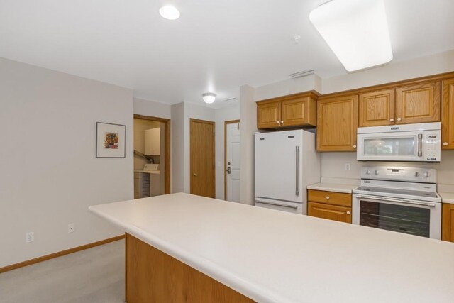 2601 Hickory Trl Unit 1, Iowa City, IA 52245 - kitchen featuring white appliances, light countertops, light carpet, and brown cabinets