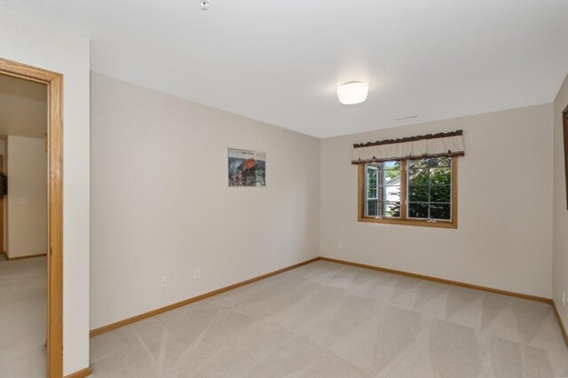 2601 Hickory Trl Unit 1, Iowa City, IA 52245 - spare room featuring light carpet and baseboards