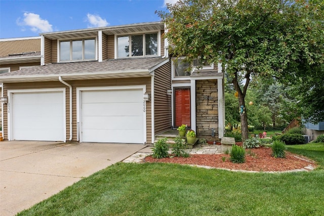 2060 Holiday Rd, Coralville, IA 52241 - view of front of home with concrete driveway, a front yard, a garage, and roof with shingles