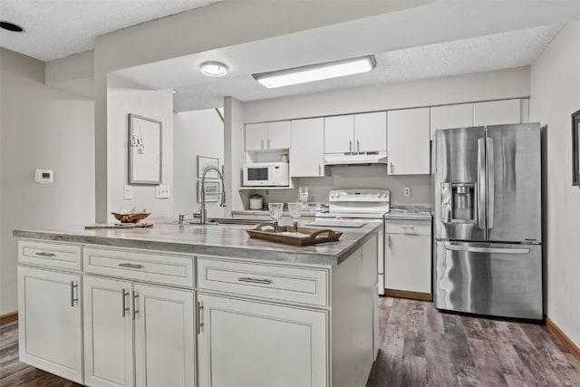 2060 Holiday Rd, Coralville, IA 52241 - kitchen with stainless steel fridge, under cabinet range hood, white microwave, dark wood-style flooring, and white cabinets