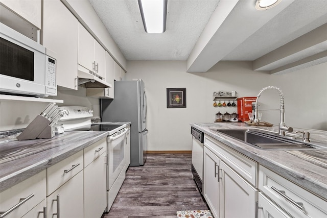 2060 Holiday Rd, Coralville, IA 52241 - kitchen with white appliances, under cabinet range hood, white cabinetry, light countertops, and dark wood finished floors