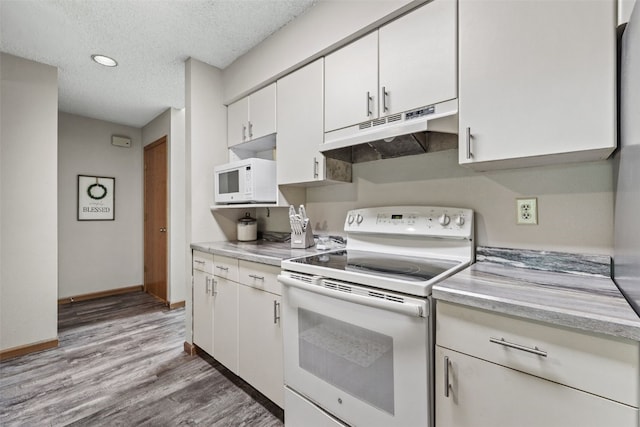 2060 Holiday Rd, Coralville, IA 52241 - kitchen featuring white appliances, under cabinet range hood, light countertops, light wood-style flooring, and a textured ceiling