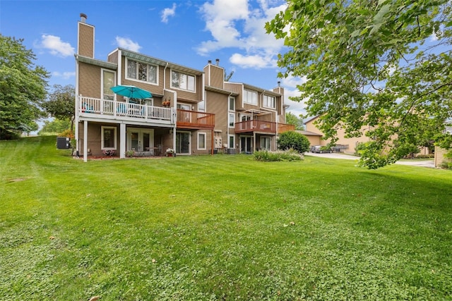 2060 Holiday Rd, Coralville, IA 52241 - back of house with a chimney, a lawn, and a wooden deck