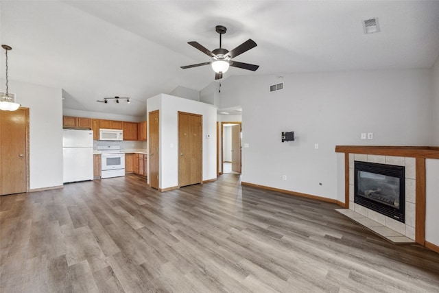 620 Colton Cir NE Unit 11, Cedar Rapids, IA 52402 - unfurnished living room featuring a ceiling fan, vaulted ceiling, a tiled fireplace, wood finished floors, and track lighting