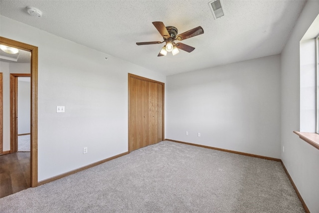 620 Colton Cir NE Unit 11, Cedar Rapids, IA 52402 - unfurnished bedroom featuring carpet, a closet, a ceiling fan, and a textured ceiling
