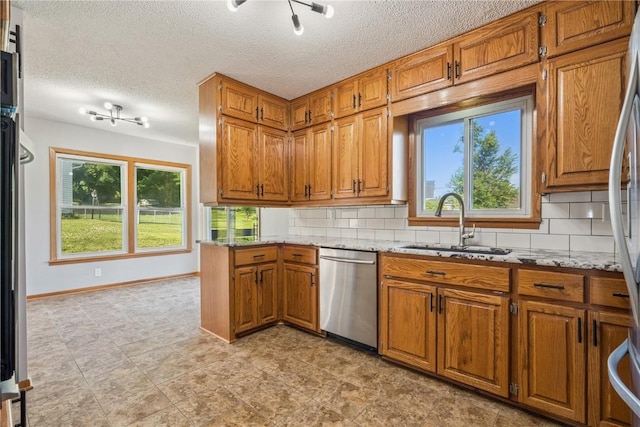 705 Grant Wood Dr SE, Cedar Rapids, IA 52403 - kitchen with stainless steel dishwasher, brown cabinets, light stone countertops, backsplash, and a textured ceiling