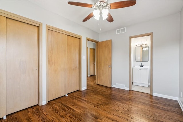 705 Grant Wood Dr SE, Cedar Rapids, IA 52403 - unfurnished bedroom with two closets, wood finished floors, ensuite bath, and ceiling fan