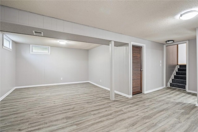 705 Grant Wood Dr SE, Cedar Rapids, IA 52403 - basement with wood finished floors, a textured ceiling, and stairs