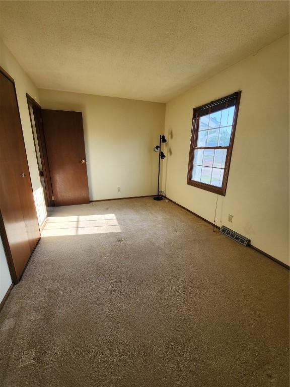 339 Fleetwood Rd SW, Cedar Rapids, IA 52404 - empty room featuring a textured ceiling and light carpet