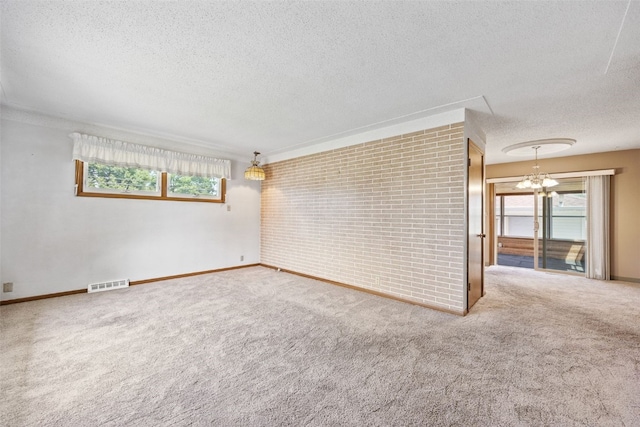 425 28th St NW, Cedar Rapids, IA 52405 - spare room featuring a textured ceiling, carpet floors, plenty of natural light, and a chandelier