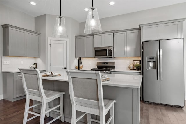19 Pond Rdg, Coralville, IA 52241 - kitchen with appliances with stainless steel finishes, gray cabinets, decorative backsplash, wood finished floors, and recessed lighting