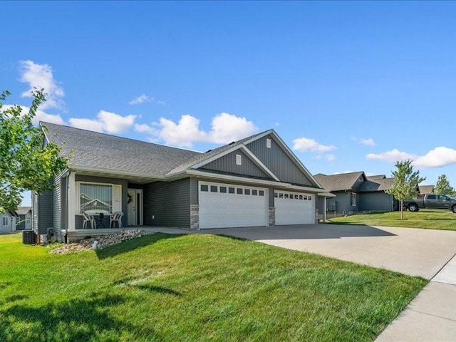 3602 Bluebird Dr SW, Cedar Rapids, IA 52404 - view of front of home featuring an attached garage, concrete driveway, a front yard, and stone siding