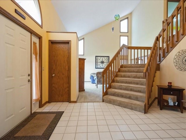2066 Vista Cir NW, Cedar Rapids, IA 52405 - foyer featuring high vaulted ceiling, stairs, light tile patterned floors, and light carpet