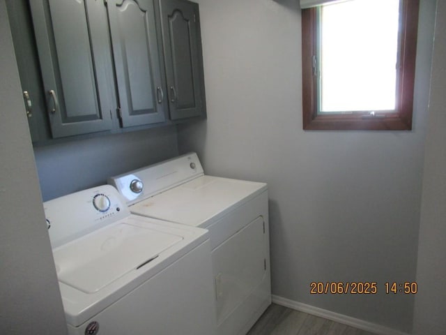 302 Meridian St, Tipton, IA 52772 - laundry area with washing machine and clothes dryer, cabinet space, and light wood finished floors