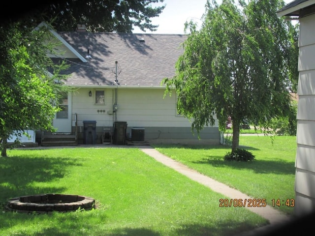 302 Meridian St, Tipton, IA 52772 - rear view of house with roof with shingles, a lawn, and entry steps