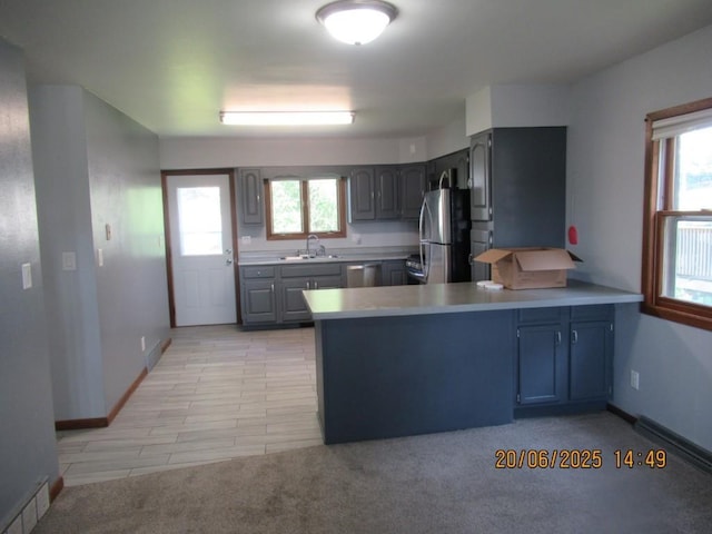 302 Meridian St, Tipton, IA 52772 - kitchen featuring stainless steel appliances, a peninsula, light countertops, and healthy amount of natural light