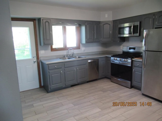302 Meridian St, Tipton, IA 52772 - kitchen with stainless steel appliances, gray cabinets, plenty of natural light, and light wood-style floors