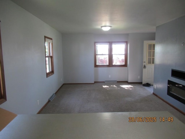302 Meridian St, Tipton, IA 52772 - unfurnished living room with carpet and a baseboard heating unit