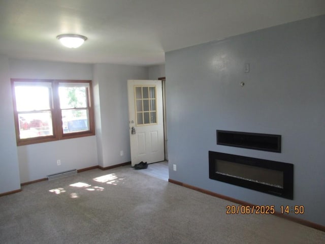 302 Meridian St, Tipton, IA 52772 - unfurnished living room featuring carpet flooring, baseboard heating, and a glass covered fireplace