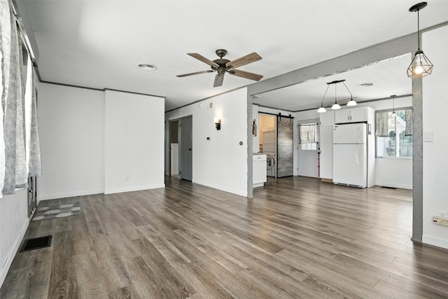 1635 Keith Dr NE, Cedar Rapids, IA 52402 - unfurnished living room with a barn door, dark wood-style flooring, and ceiling fan