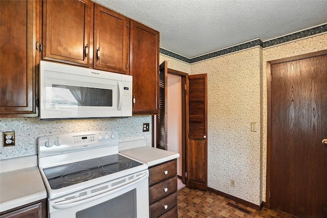 4121 Lexington Dr NE Unit B, Cedar Rapids, IA 52402 - kitchen with white appliances, wallpapered walls, light countertops, and a textured ceiling