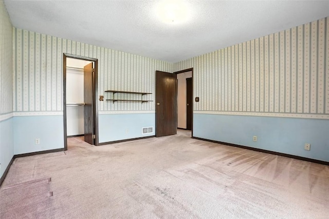 4121 Lexington Dr NE Unit B, Cedar Rapids, IA 52402 - spare room with carpet, wallpapered walls, and a textured ceiling