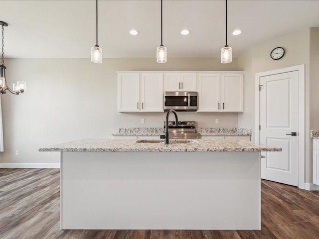 1326 Echo Ridge Ln, Marion, IA 52302 - kitchen with stainless steel appliances, dark wood-style floors, white cabinetry, light stone counters, and a kitchen island with sink
