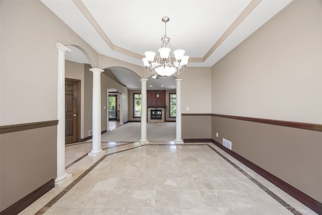 4452 Plumberry Rd, Ely, IA 52227 - empty room featuring ornate columns, inlaid floor details, arched walkways, a chandelier, and a raised ceiling