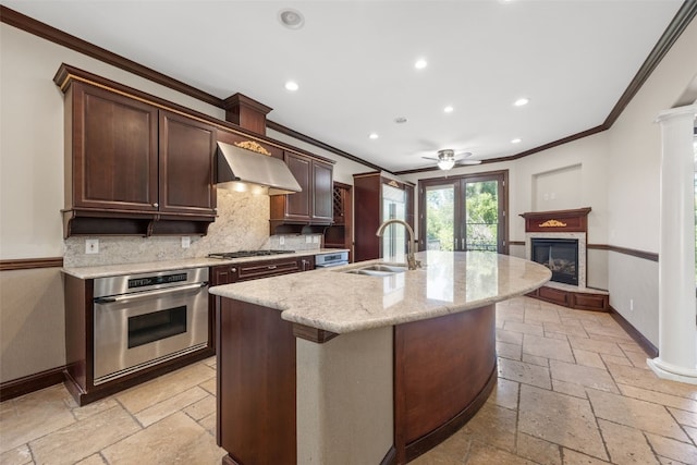 4452 Plumberry Rd, Ely, IA 52227 - kitchen with stainless steel appliances, stone tile floors, crown molding, wall chimney range hood, and decorative backsplash
