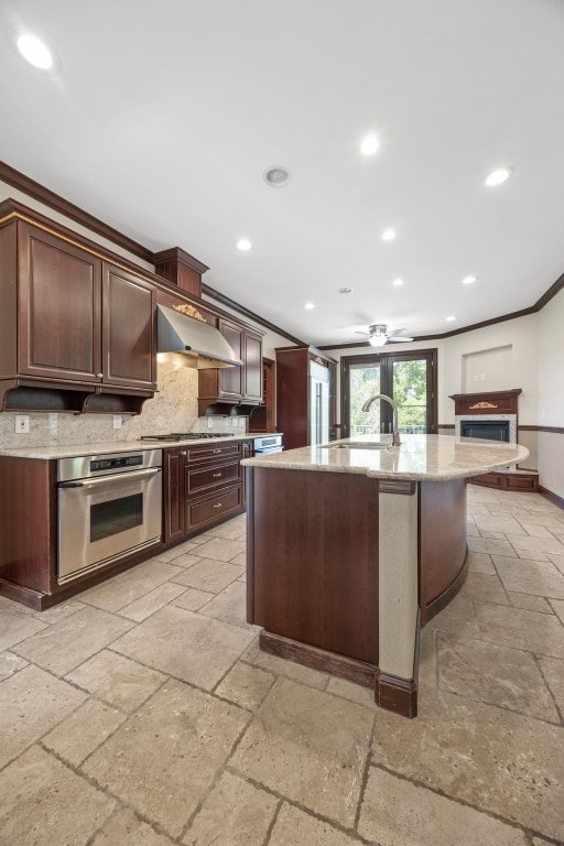 4452 Plumberry Rd, Ely, IA 52227 - kitchen featuring stainless steel appliances, stone tile flooring, wall chimney exhaust hood, backsplash, and crown molding