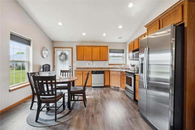 1727 Hunters Creek Way, Marion, IA 52302 - kitchen featuring stainless steel appliances, vaulted ceiling, dark wood-type flooring, recessed lighting, and light countertops