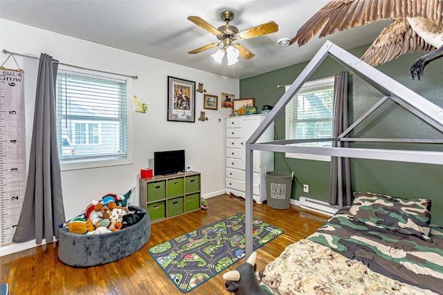21 Mill St, Walker, IA 52352 - bedroom featuring baseboard heating, multiple windows, and wood finished floors