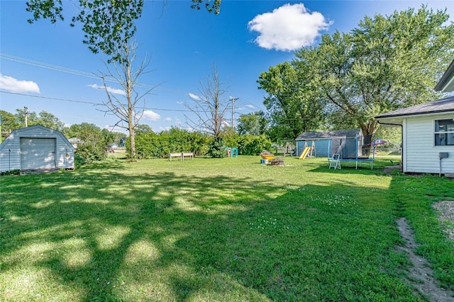 21 Mill St, Walker, IA 52352 - view of grassy yard featuring a shed, a trampoline, and a playground