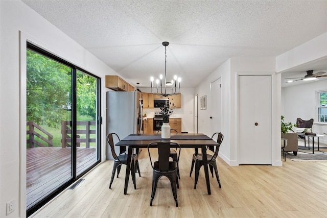 1642 19th St, Cedar Rapids, IA 52405 - dining room featuring light wood finished floors, a chandelier, and a textured ceiling