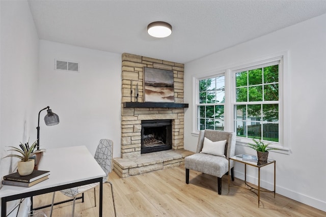 1642 19th St, Cedar Rapids, IA 52405 - living area featuring wood finished floors, a fireplace, and a textured ceiling