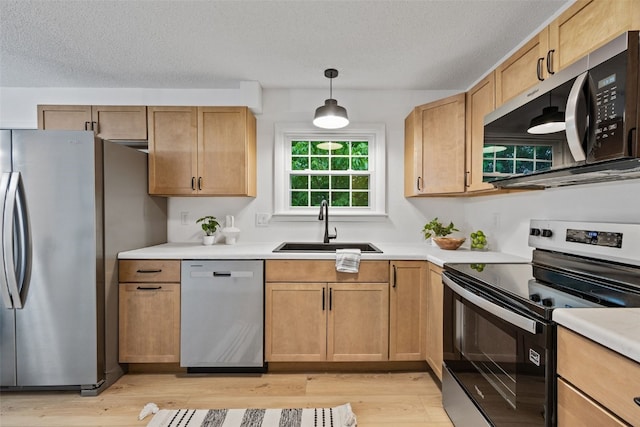 1642 19th St, Cedar Rapids, IA 52405 - kitchen with appliances with stainless steel finishes, light wood-style floors, light countertops, a textured ceiling, and hanging light fixtures