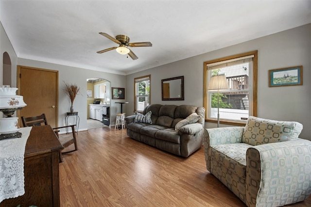 913 32nd St SE, Cedar Rapids, IA 52403 - living area featuring arched walkways, ceiling fan, and light wood-style floors