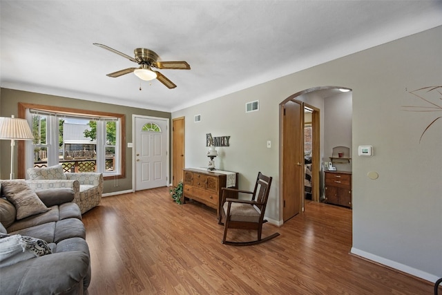 913 32nd St SE, Cedar Rapids, IA 52403 - living room featuring arched walkways, a ceiling fan, and wood finished floors
