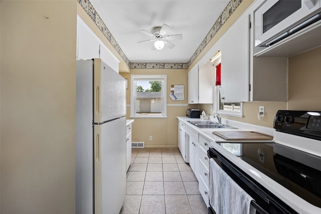 913 32nd St SE, Cedar Rapids, IA 52403 - kitchen with electric range oven, freestanding refrigerator, and white cabinets