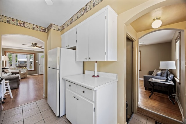 913 32nd St SE, Cedar Rapids, IA 52403 - kitchen with arched walkways, a ceiling fan, freestanding refrigerator, open floor plan, and light tile patterned floors