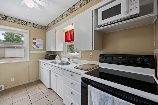 913 32nd St SE, Cedar Rapids, IA 52403 - kitchen with electric stove, white microwave, plenty of natural light, and light countertops