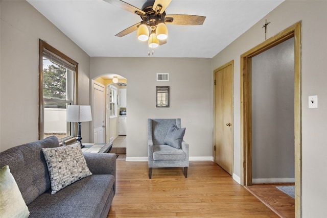 913 32nd St SE, Cedar Rapids, IA 52403 - living area featuring arched walkways, ceiling fan, and light wood-style floors