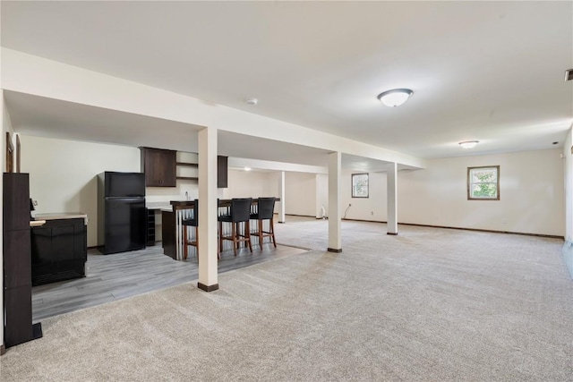 6752 29th Ave, Shellsburg, IA 52332 - below grade area with freestanding refrigerator, bar area, and light colored carpet