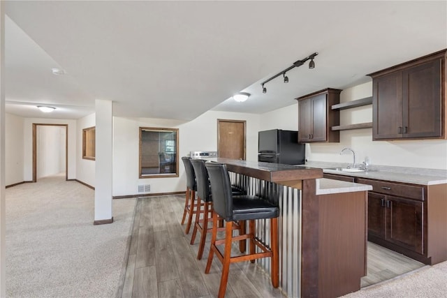 6752 29th Ave, Shellsburg, IA 52332 - kitchen featuring freestanding refrigerator, dark brown cabinetry, rail lighting, open shelves, and a kitchen island
