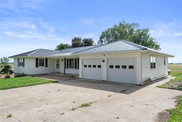 6752 29th Ave, Shellsburg, IA 52332 - ranch-style house with concrete driveway, an attached garage, and a metal roof