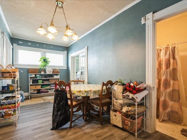 1551 C Ave NE, Cedar Rapids, IA 52402 - dining space with wood finished floors, ornamental molding, a textured ceiling, and a chandelier