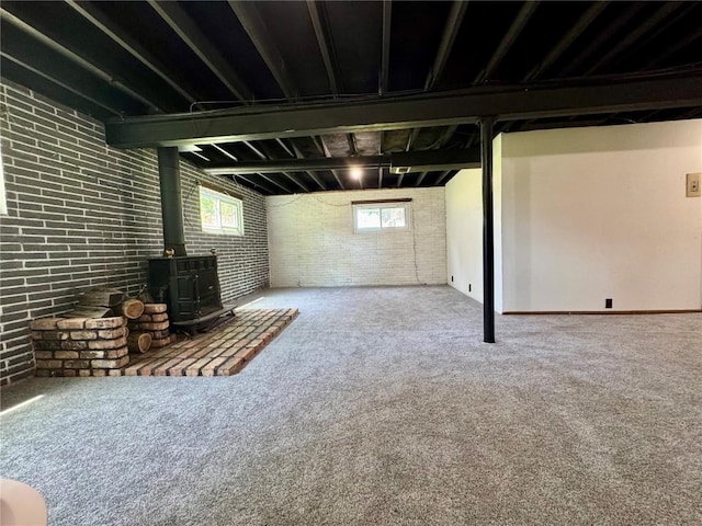 72 Fleetwood Rd NW, Cedar Rapids, IA 52405 - basement with brick wall, a wood stove, and carpet flooring