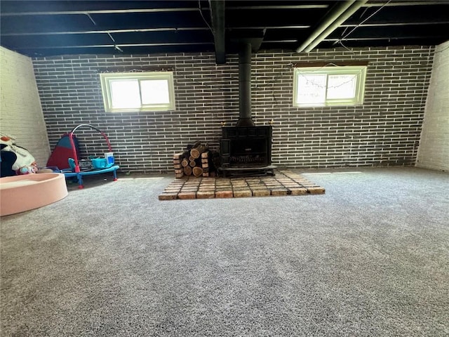 72 Fleetwood Rd NW, Cedar Rapids, IA 52405 - basement featuring a wood stove, carpet, and brick wall