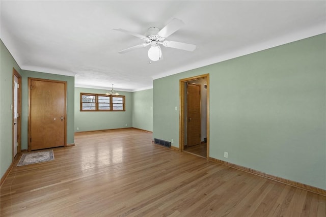 340 18th St NW, Cedar Rapids, IA 52405 - unfurnished room with a chandelier, light wood-style flooring, and ceiling fan