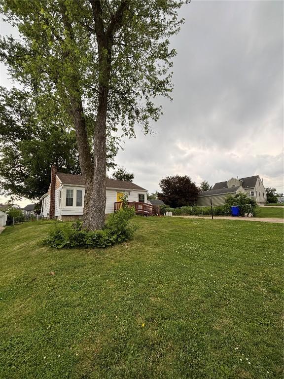 143 21st St SW, Cedar Rapids, IA 52404 - view of grassy yard featuring a wooden deck